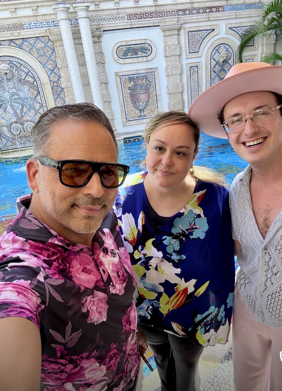 Natalie Hirsch with two friends in front of a mosaic poolside courtyard, sunny and colorful